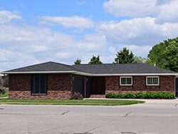 Modern brick house in Norfolk, VA with driveway and trees.